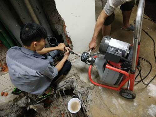 Kỹ thuật viên xử lý thông tắc cống bằng máy lò xo hiện đại – thi công an toàn, triệt để