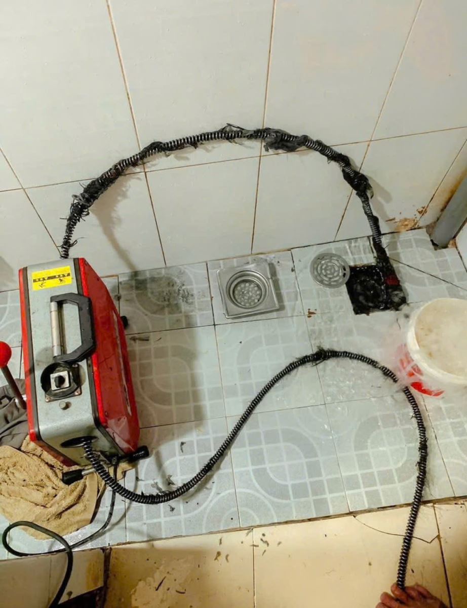 Máy hút áp lực cao đang loại bỏ rác thải, dầu mỡ bên trong đường ống chung cư